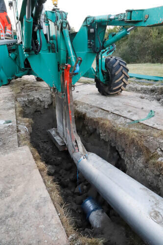 Der Pflug zieht die neue Wasserleitung ein.