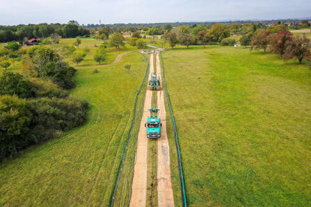 Mit großem Gerät wird die neue Wasserleitung unter die Erde gebracht.