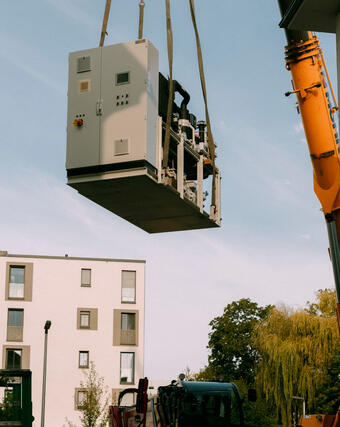 Die Anlagetechnik für das neue Blockheizkraftwerk (BHKW) fürs Joffre-Areal wird per Kran „eingeflogen“.